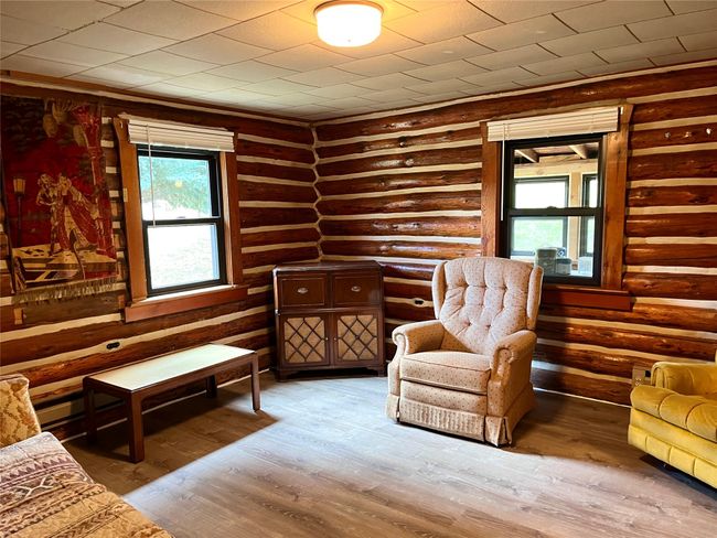Sitting room with rustic walls and wood finished floors | Image 9