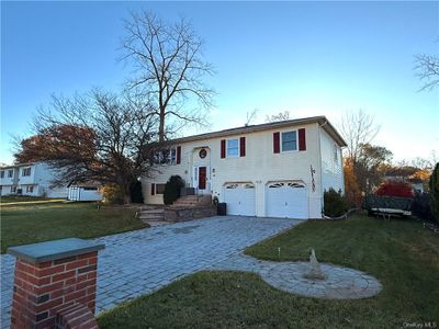 Split foyer home with a front lawn and a garage | Image 1