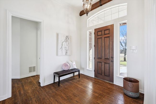 Foyer with a chandelier, wood finished floors, and baseboards | Image 4