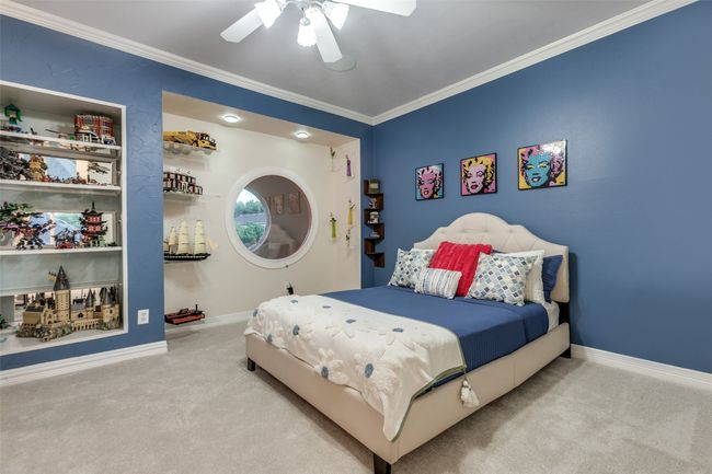 One of 2 upstairs bedrooms. This room offers built-in shelving, a large walk-in closet, a Jack & Jill bathroom, and a cool circular window (that lines up amazingly with a second circular window across the hallway, offering a great glimpse of the back yard) | Image 28