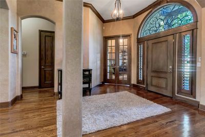 Entryway with a high ceiling, dark hardwood / wood-style flooring, an inviting chandelier, and crown molding | Image 3