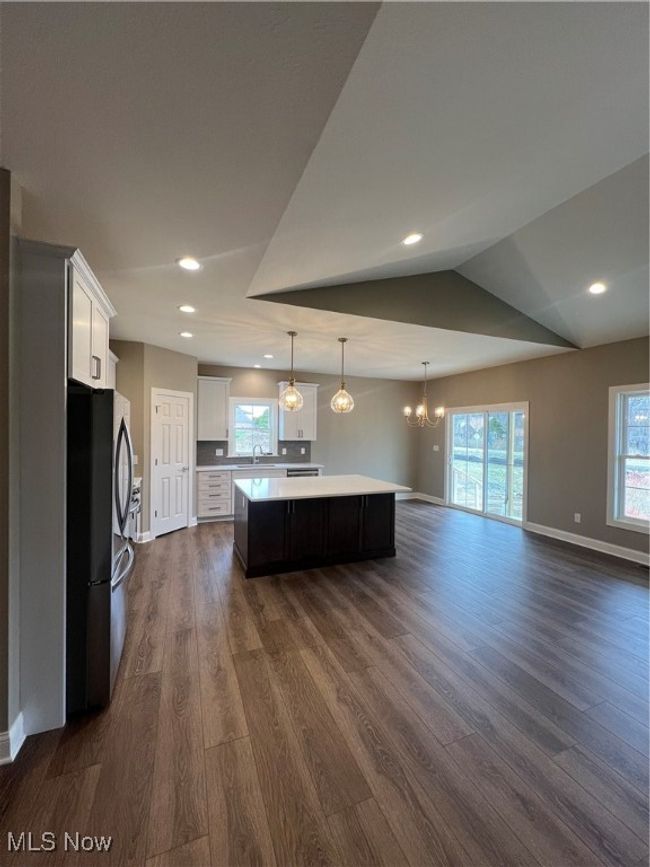 Kitchen featuring a kitchen island, a chandelier, light countertops, dark wood finished floors, and refrigerator | Image 19