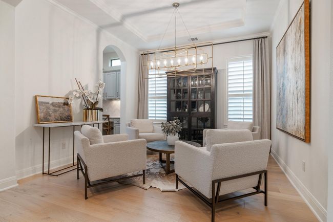 Living or dining area featuring crown molding, a chandelier, arched walkways, light wood-style floors, and plenty of natural light | Image 19
