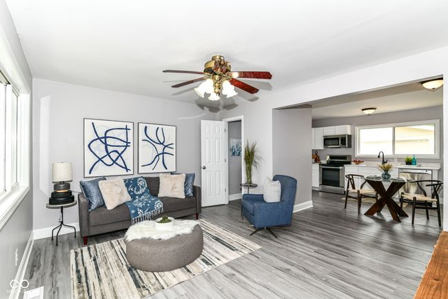 living room with wood finished floors, ceiling fan, and baseboards | Image 5