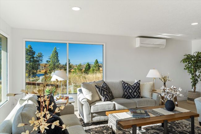 Living room with hardwood / wood-style flooring, a healthy amount of sunlight, and an AC wall unit | Image 13