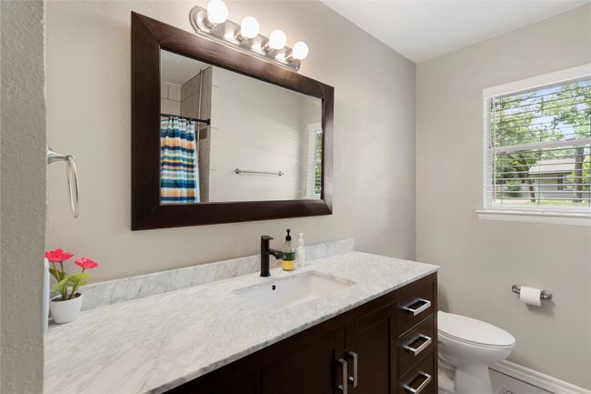 Bathroom with vanity, toilet, curtained shower, and baseboards | Image 9