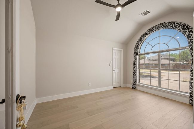 Spare room featuring visible vents, light wood-style floors, ceiling fan, and vaulted ceiling | Image 5