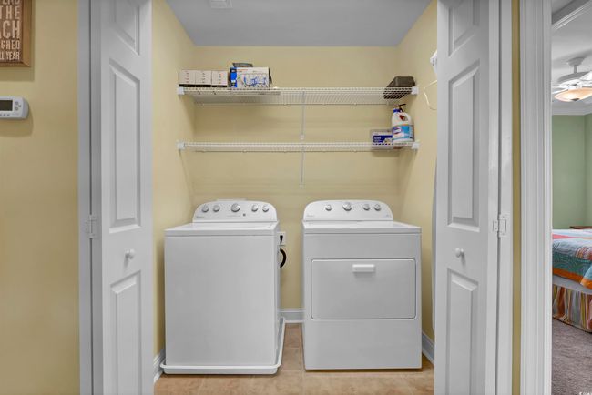 Laundry area featuring independent washer and dryer and light tile patterned floors | Image 24
