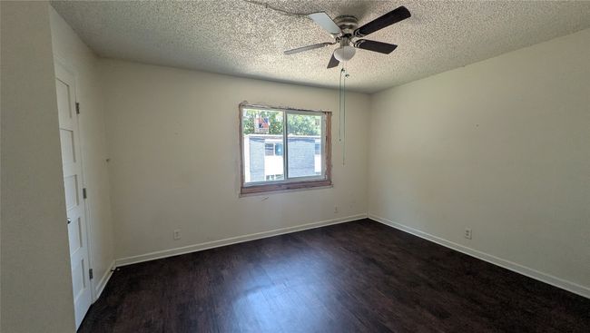 Unfurnished room featuring dark wood-style flooring, a textured ceiling, and ceiling fan | Image 9