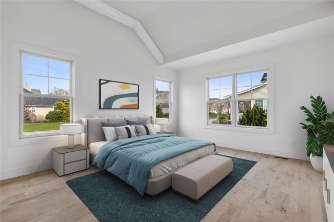 Bedroom with lofted ceiling, wood finished floors, and multiple windows | Image 9