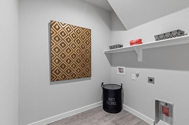 Washroom with gas dryer hookup, electric dryer hookup, washer hookup, and tile flooring. | Image 22