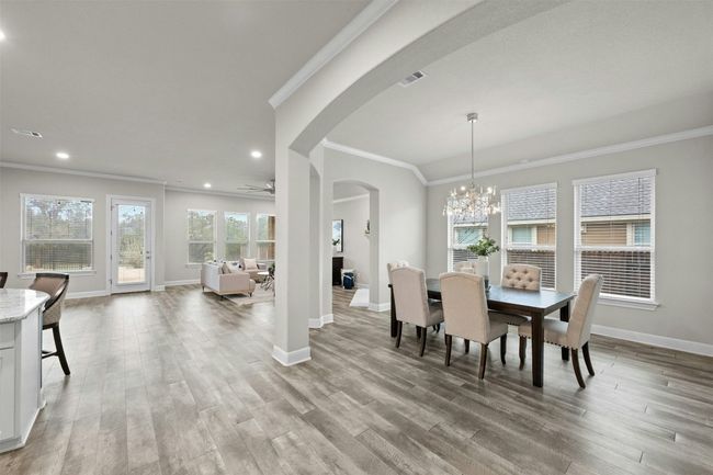 Inside, an open-concept floorplan bathed in natural light welcomes you with a neutral color palette and rich hardwood flooring throughout the main living areas. | Image 4