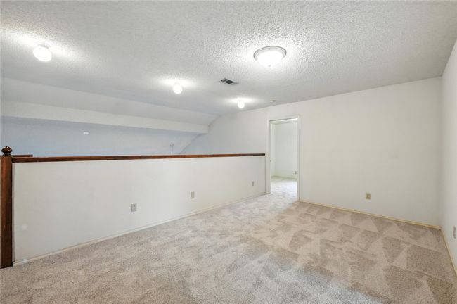 Empty room with carpet, a textured ceiling, and lofted ceiling | Image 25