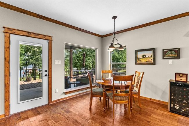 Dining space featuring wood-type flooring, beverage cooler, and ornamental molding | Image 19