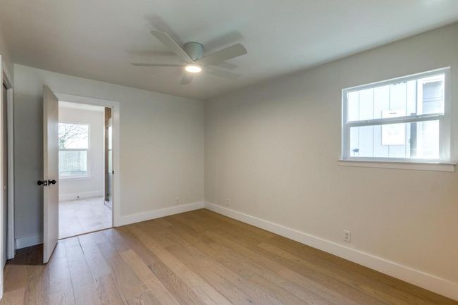 Empty room with baseboards, ceiling fan, and light wood-style floors | Image 22