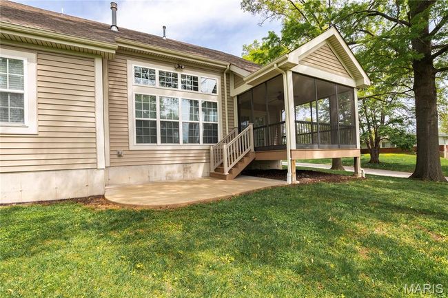 Rear view of property featuring a lawn, screened in porch area, and patio | Image 46