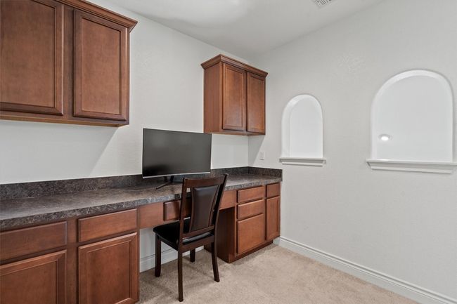 Home office with built in study area, light carpet, and baseboards | Image 18