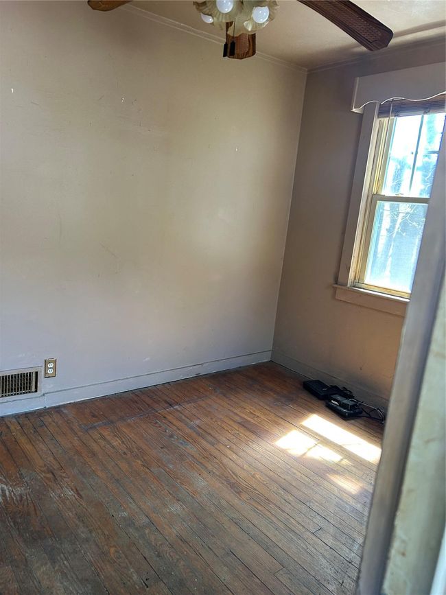 Spare room featuring baseboards, visible vents, ceiling fan, hardwood / wood-style floors, and ornamental molding | Image 14