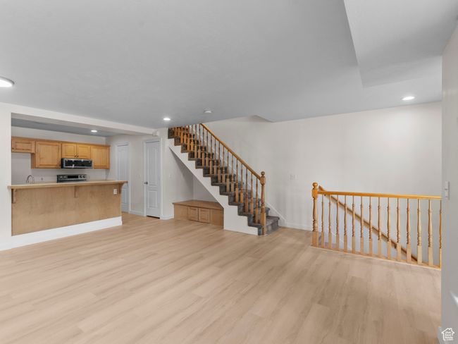 Unfurnished living room with light wood-type flooring, recessed lighting, and stairway | Image 4