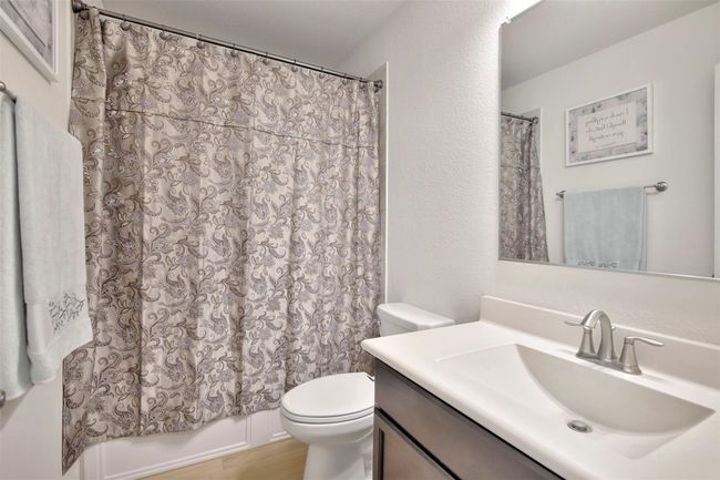 Bathroom with toilet, vanity, shower / bath combo with shower curtain, and wood finished floors | Image 20