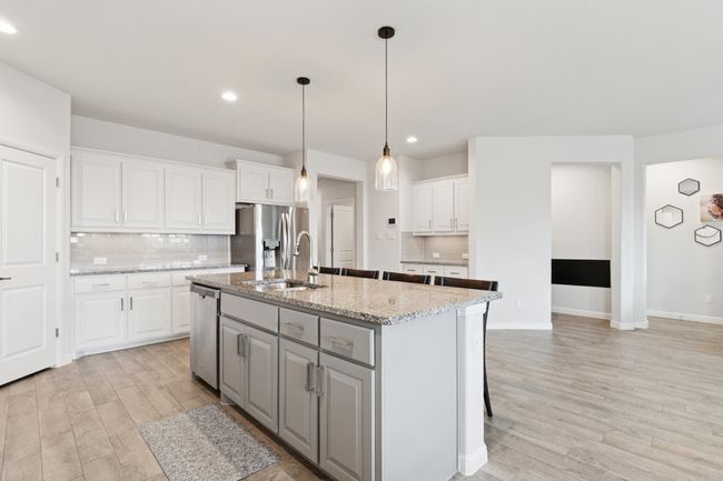 Kitchen featuring stainless steel appliances, light wood-style floors, white cabinets, decorative backsplash, and gray cabinets | Image 11