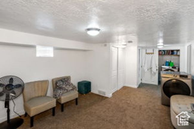 Sitting room with a textured ceiling and carpet flooring | Image 26