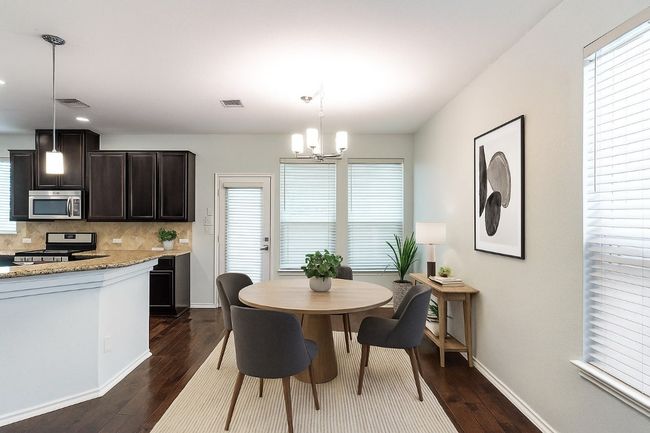 Virtually Staged Dining area featuring a chandelier and dark wood-style flooring | Image 32