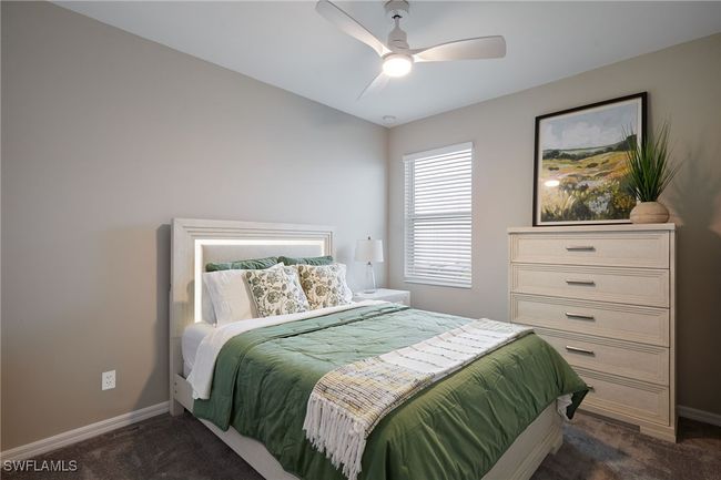 Bedroom featuring dark colored carpet, ceiling fan, and baseboards | Image 11