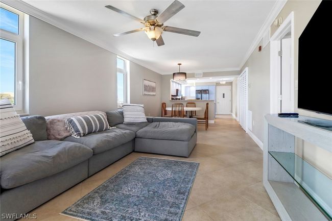 Living room featuring ceiling fan, ornamental molding, and light tile patterned floors | Image 14