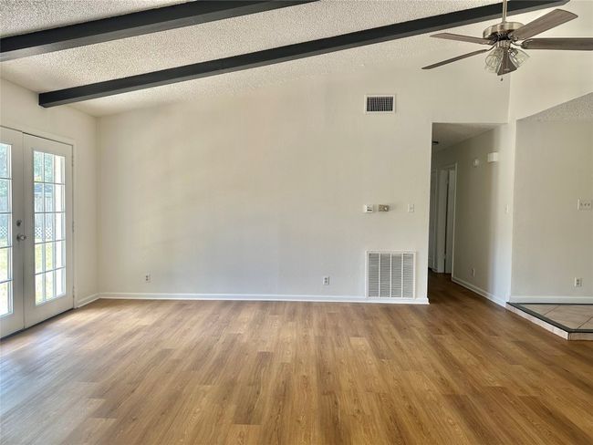 Unfurnished room featuring ceiling fan, a textured ceiling, wood finished floors, and french doors | Image 10