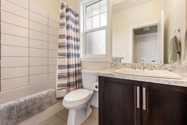 Full bathroom featuring toilet, vanity, and shower / bathtub combination with curtain | Image 29