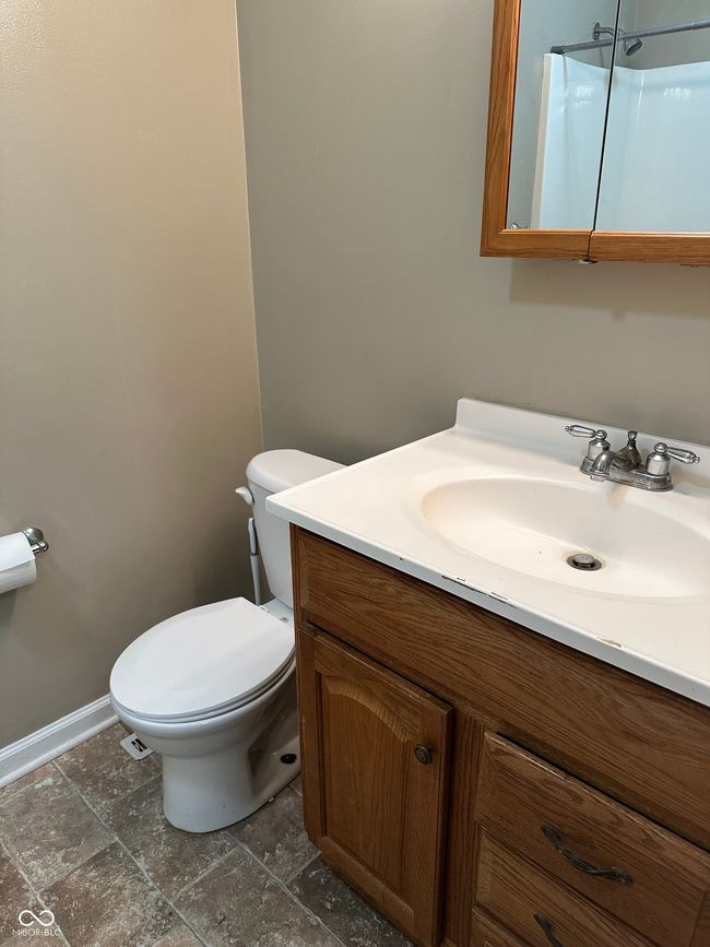 bathroom featuring vanity, stone finish floors, and a shower | Image 13