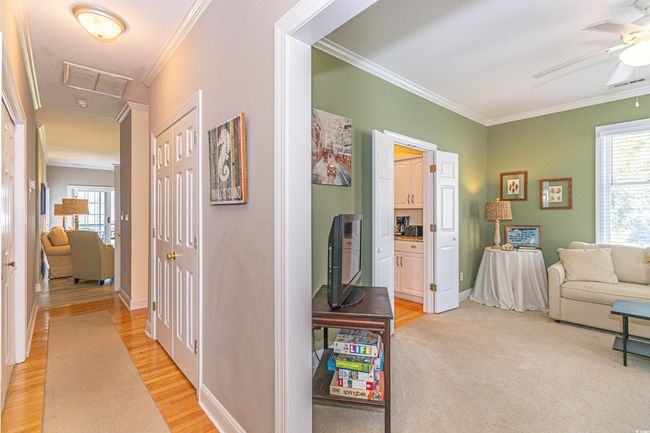 Hall with crown molding, baseboards, visible vents, and attic access | Image 27