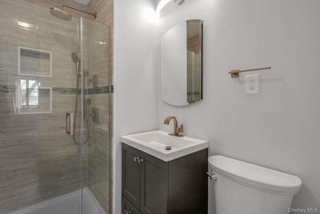 Full bathroom with toilet, a stall shower, and vanity | Image 22