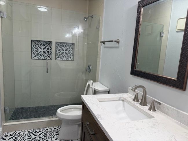 Bathroom with vanity, a stall shower, and tile patterned flooring | Image 10