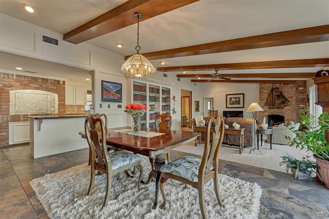 Slate tile flooring extends from the dining area into the kitchen, creating a cohesive and durable surface throughout these areas. | Image 15
