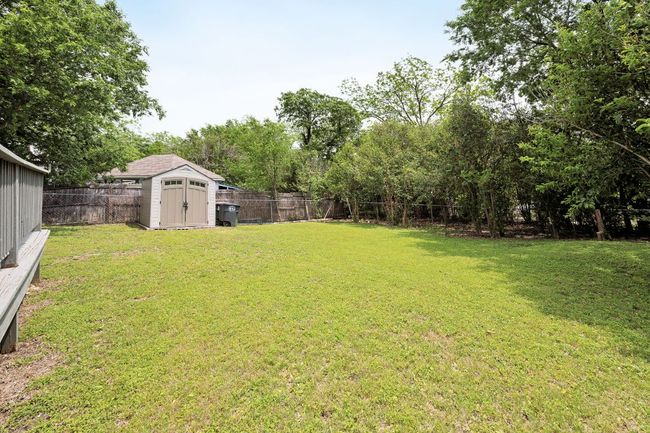 View of yard featuring a storage unit, a fenced backyard, and an outdoor structure | Image 34