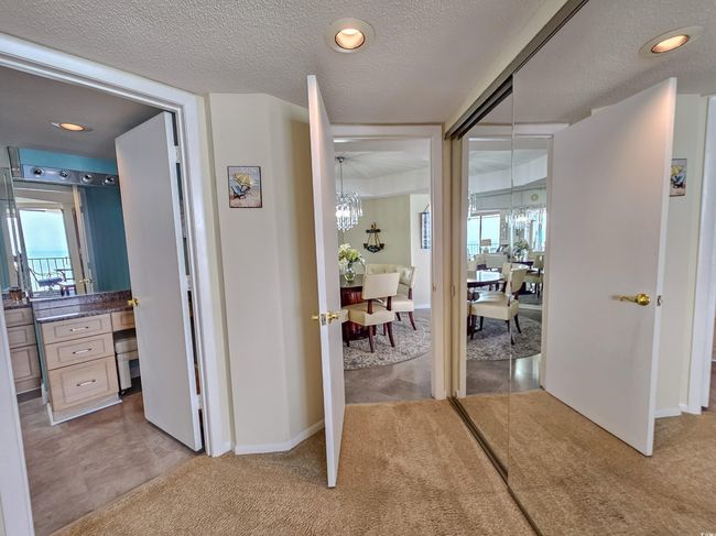 Corridor with a chandelier, light carpet, a textured ceiling, and recessed lighting | Image 24