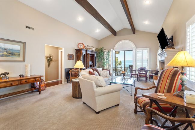 Living area with beamed ceiling, light colored carpet, high vaulted ceiling, recessed lighting, and a fireplace | Image 10