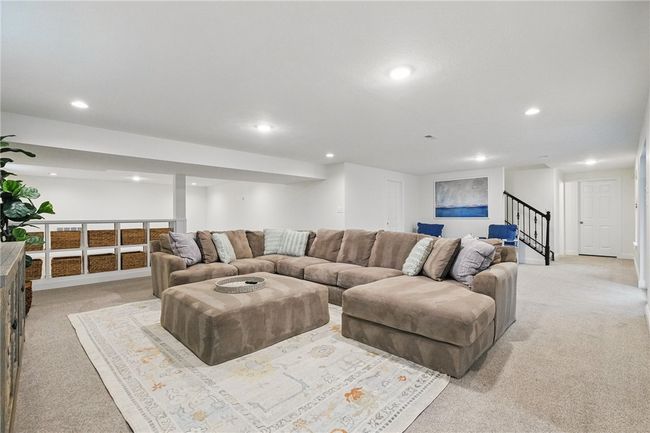 Expansive finished basement offering a versatile layout perfect for a media room, playroom, billiard room or entertaining space. Features recessed lighting, plush carpeting, and neutral tones throughout—complete with a walk-out door for easy outdoor access to lower level covered patio and added convenience. | Image 29