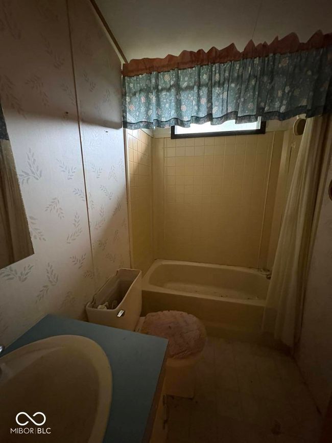 bathroom with vanity, shower / bath combination with curtain, and wallpapered walls | Image 20