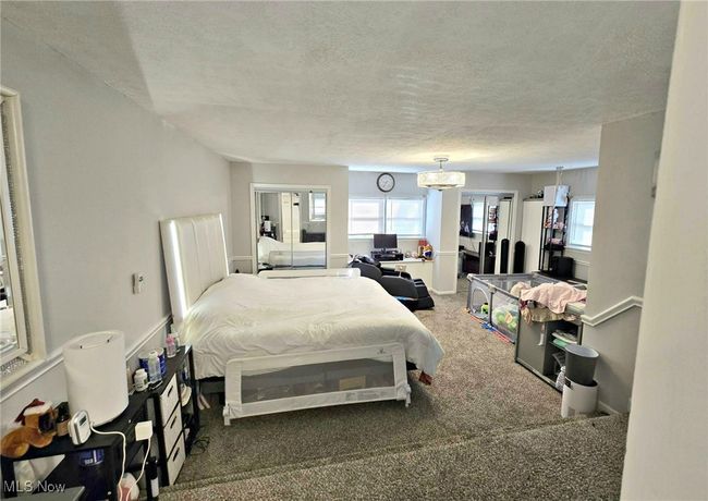 Bedroom with carpet flooring, multiple windows, and a textured ceiling | Image 29