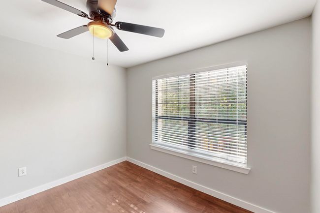 Empty room featuring baseboards, wood finished floors, and a ceiling fan | Image 32