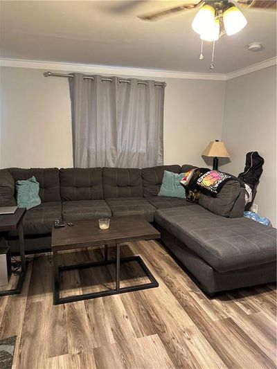 Living room featuring ceiling fan, hardwood / wood-style flooring, and crown molding | Image 2