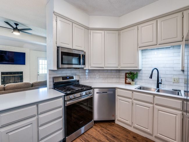Kitchen with appliances with stainless steel finishes, light countertops, ceiling fan, and a textured ceiling | Image 6