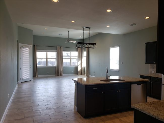 Kitchen featuring ceiling fan, an island with sink, healthy amount of natural light, recessed lighting, and open floor plan | Image 7