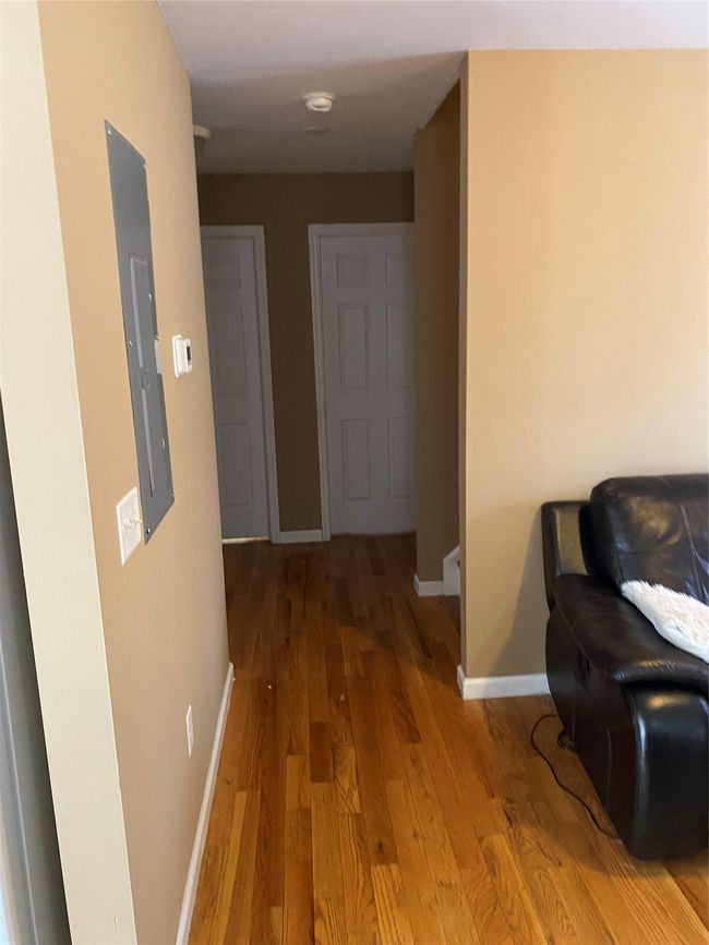 Hallway with wood finished floors, electric panel, and baseboards | Image 8
