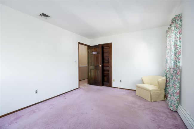 Unfurnished room featuring baseboards, visible vents, light colored carpet, and a baseboard radiator | Image 24