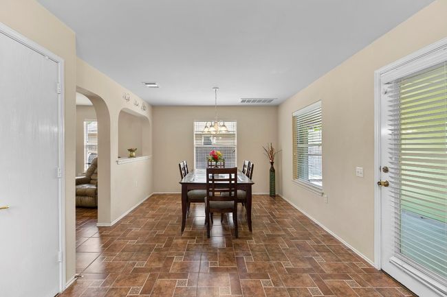 Dining room featuring a chandelier, dark stone finish floors, and arched​​‌​​​​‌​​‌‌​‌‌​​​‌‌​​‌‌​‌​​​​​‌ walkways | Image 21