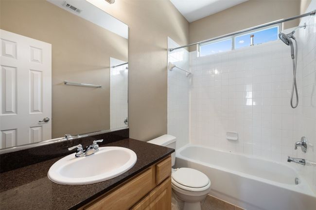 Bathroom with toilet, vanity, and bathtub / shower combination | Image 28